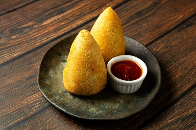 Deux coxinhas brésiliennes traditionnelles, snacks frits typiques, farcis de viande et de poulet