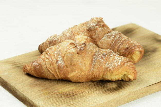 Deux croissants frais sur un fond rustique en bois