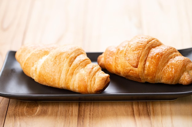 Deux croissants sont sur l'assiette Croissant est une pâtisserie française feuilletée au beurre Ce pain utilise la pâte feuilletée levée française Croustillant et délicieux