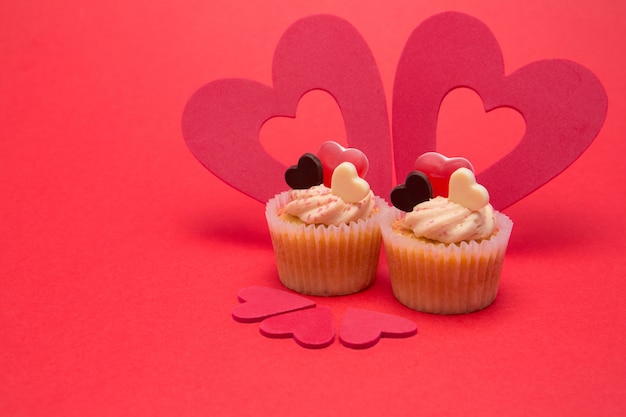 Photo deux cupcakes de la saint-valentin avec cinq décorations de coeur