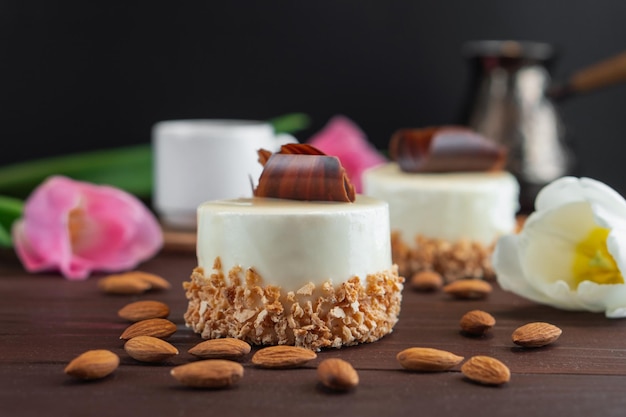 Deux cupcakes avec une tasse de café blanc au chocolat, des amandes et des tulipes sur une table en bois Mise au point sélective