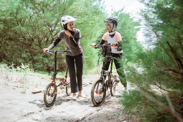 Deux cyclistes musulmanes fatiguées après avoir traversé la route sablonneuse