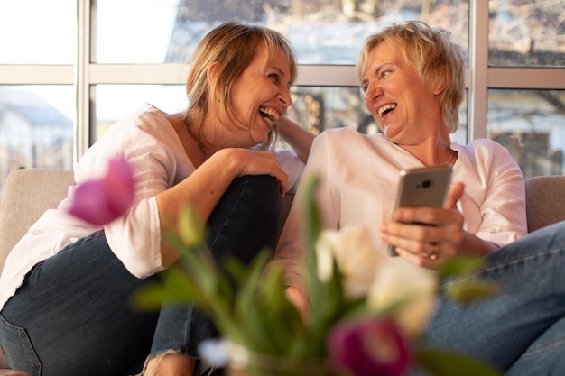 Deux dames de 55 ans riant joyeusement, se regardant, concept d'amitié féminine