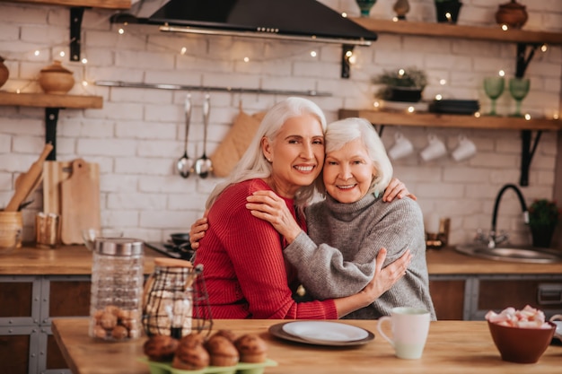 Deux dames positives aux cheveux gris matures se sentent bien ensemble