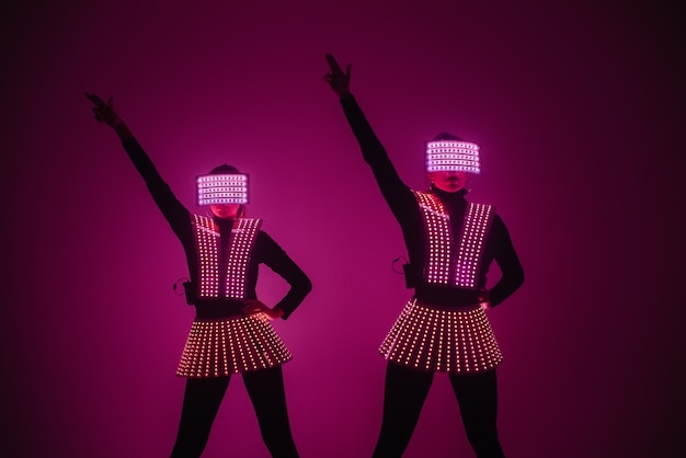 Deux danseuses disco sexy se déplacent en costumes UV. Fêtes et danses.