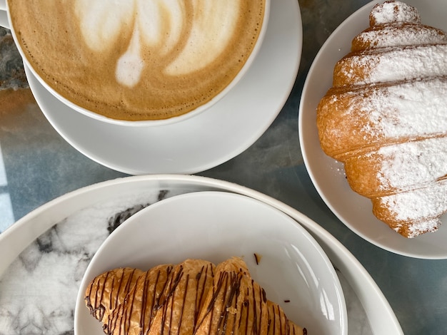 Deux délicieux croissants et une tasse de cappuccino revigorant sur la table en gros plan