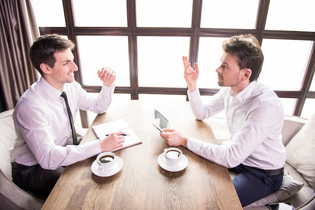 Deux discussions de travail de jeunes hommes d'affaires.