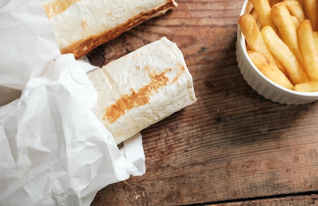 Deux doners et frites avec sauce au fromage sur une vue de dessus de fond en bois Shawarma sur une table en bois Livraison de nourriture