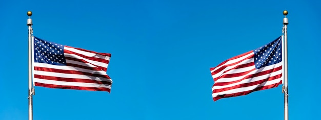 Deux drapeaux des États-Unis sur le mât agitant contre le ciel bleu espace d'image panoramique pour le texte
