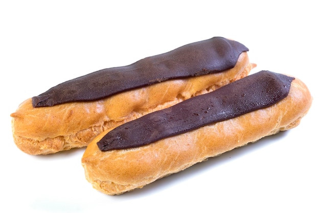 Deux éclairs au chocolat noir avec crème anglaise à l'intérieur sur fond blanc