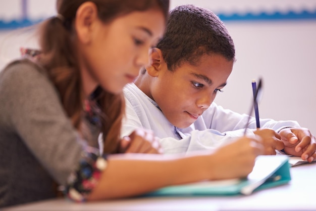 Deux élèves du primaire travaillant au bureau pendant une leçon