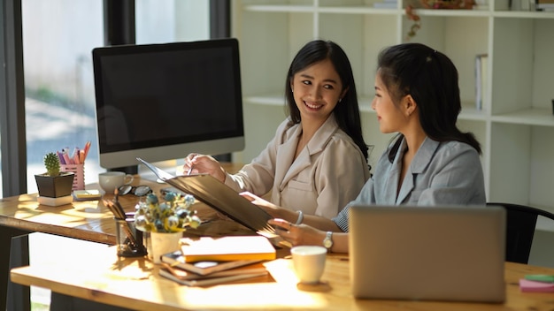 Deux employées d'affaires asiatiques travaillent sur le projet ensemble concept de travail d'équipe collègue