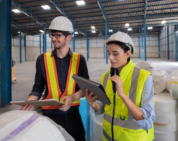 Deux employés de l'entrepôt en uniforme vérifient la qualité et le stock de fibres pour la production de masques en fonction de la capacité de commande des clients