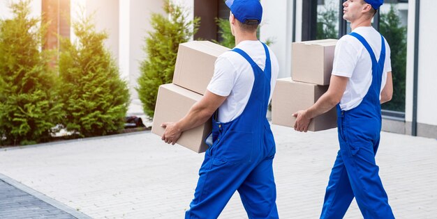 Deux employés d'une entreprise de déménagement chargent des cartons dans un minibus