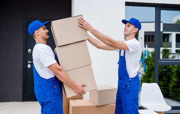 Deux employés d'une entreprise de déménagement chargent des cartons dans un minibus