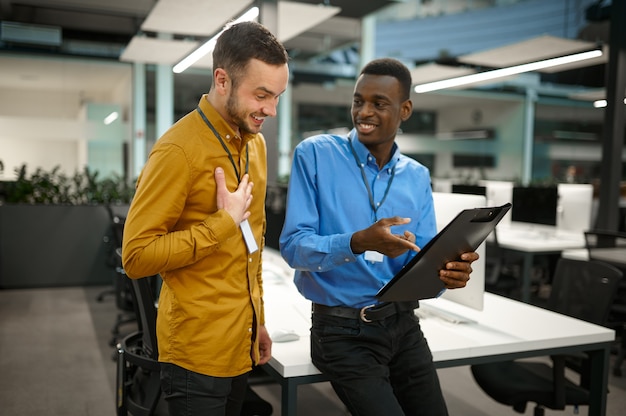 Deux employés masculins, se réunissant dans le bureau informatique