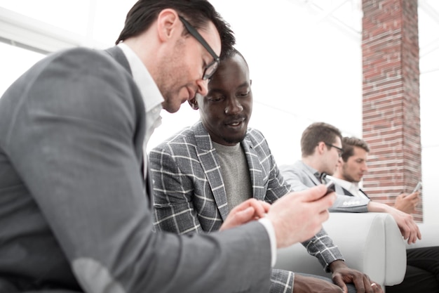 Deux employés regardent et lisent sur l'écran du smartphone