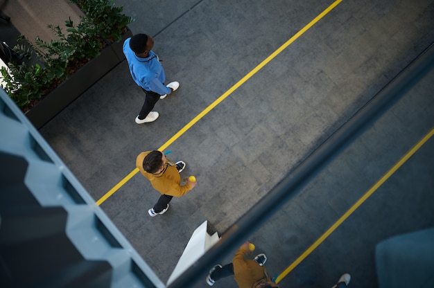 Deux employés, vue de dessus depuis le balcon du bureau informatique