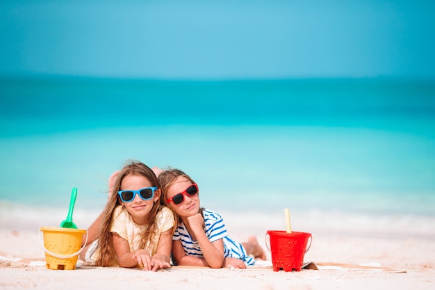 Deux enfants faisant un château de sable et s'amusant sur une plage tropicale