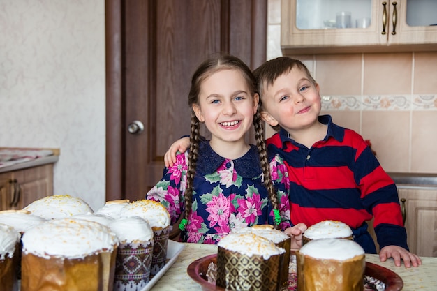 Deux enfants, une fille et un garçon, un frère et une sœur, glaçant un gâteau de Pâques.