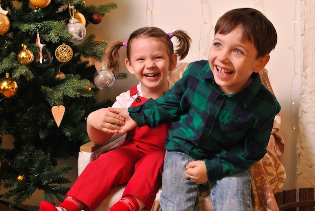 Deux enfants garçon et fille jouant à proximité de l'arbre de Cristmas