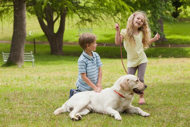 Deux enfants heureux avec chien dans le parc