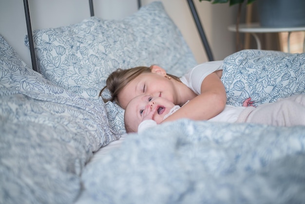 deux enfants jouant au lit