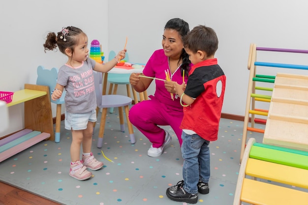 Deux enfants jouent avec le médecin pédiatre dans l'aire de jeux du cabinet médical