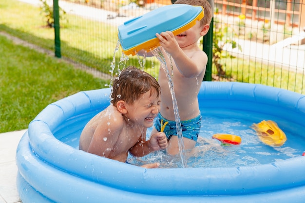 Deux enfants avec des jouets à la piscine