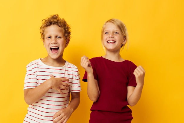 Deux enfants joyeux debout côte à côte posant des émotions d'enfance fond isolé