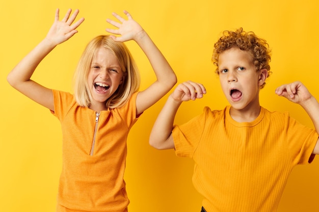 Deux enfants joyeux jeux de vêtements décontractés s'amusant ensemble posant sur fond coloré