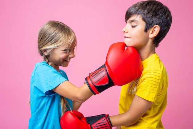 Deux enfants ludiques boxant avec des gants rouges