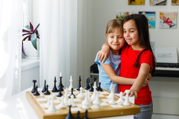 Deux enfants mignons jouant aux échecs à la maison