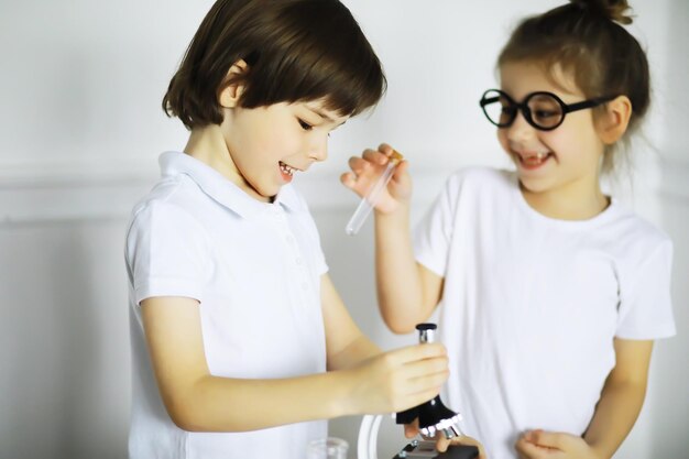 Deux Enfants Mignons à La Leçon De Chimie Faisant Des Expériences Isolées Sur Fond Blanc