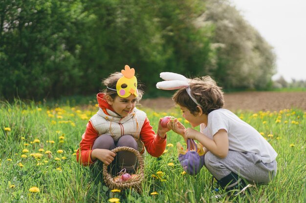 Deux enfants à la recherche d'œufs de Pâques dans un jardin de printemps