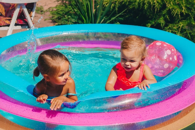 Deux enfants s'amusent dans une piscine gonflable