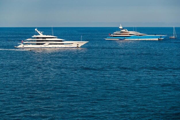 Les deux énormes méga yachts sont amarrés en mer aux beaux jours, la main courante chromée reflète le soleil sur