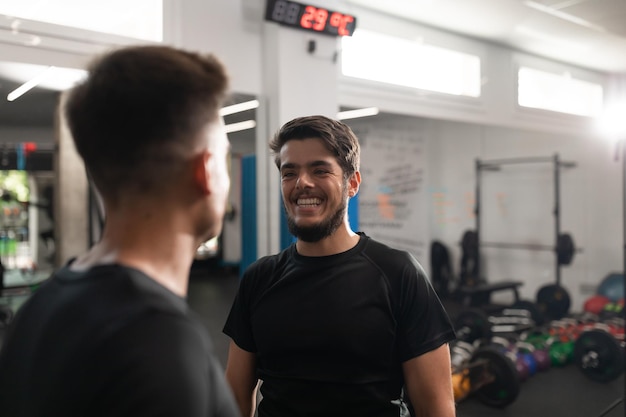 Deux entraîneurs personnels se sourient au gymnase