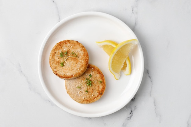 Deux escalopes de poisson ou de poulet saumon cuit au four sur une plaque blanche