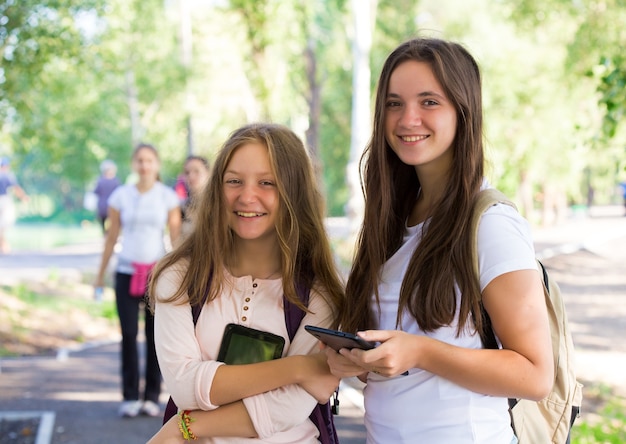 Deux étudiantes souriantes avec les comprimés à l'extérieur
