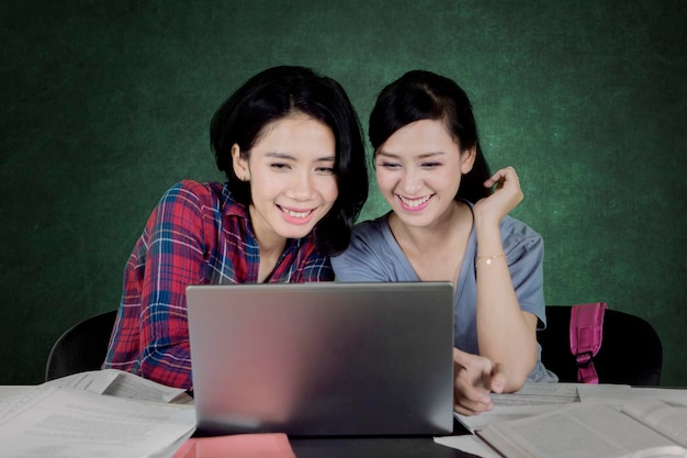 Deux étudiantes utilisant un ordinateur portable en classe