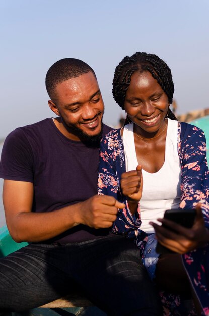 Deux étudiants africains mignons se sentent excités par ce qu'ils ont vu sur leur téléphone portable