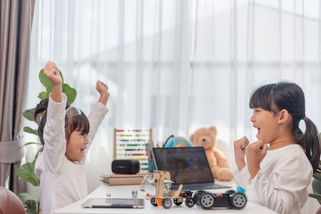 Deux étudiants asiatiques apprennent à coder des voitures robotisées et des câbles de cartes électroniques dans STEM STEAM mathématiques ingénierie science technologie code informatique dans la robotique pour les concepts pour enfants