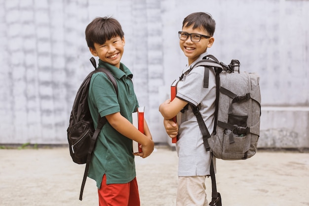 Deux étudiants asiatiques souriant et prenant une photo ensemble