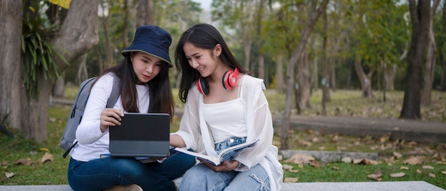 Deux étudiants assis ensemble sur un banc du campus.