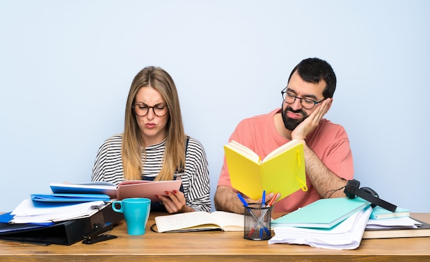 Deux étudiants avec beaucoup de livres et stressés