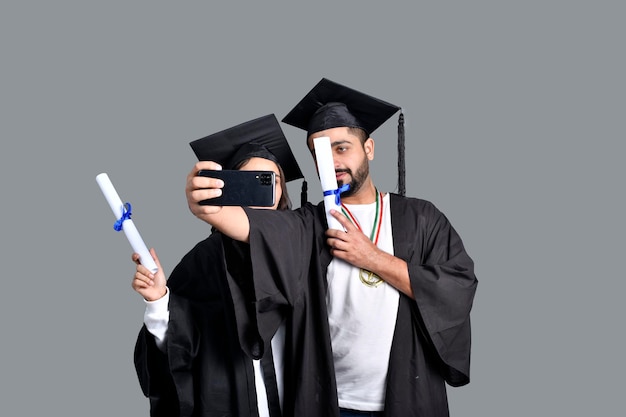 Deux étudiants diplômés prenant le modèle pakistanais indien salfie