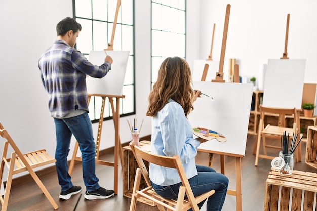 Deux étudiants hispaniques souriant peinture heureuse à l'école d'art