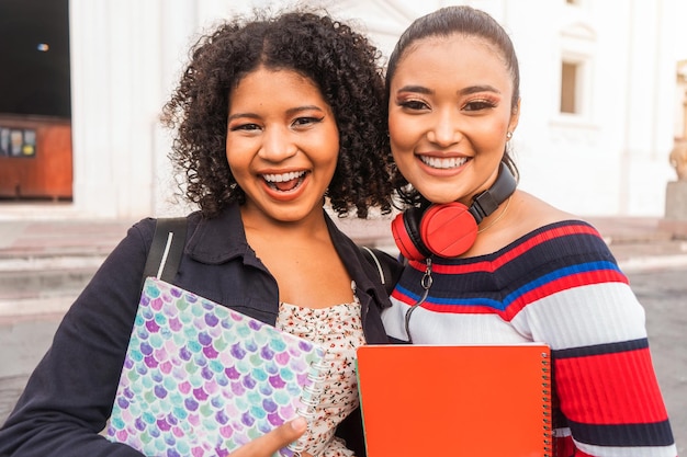 Deux étudiants latins un métis et un hispanique regardant la caméra et souriant