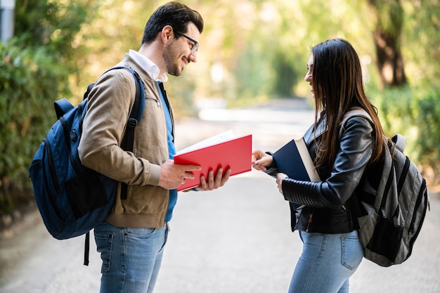 Deux étudiants parlant à l'extérieur tenant des livres